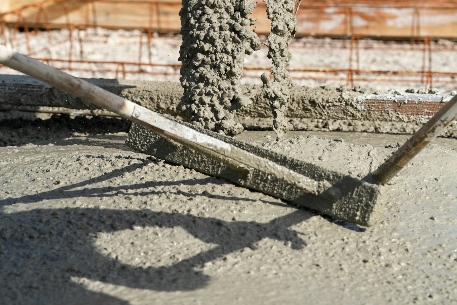 Concrete being leveled with a screed