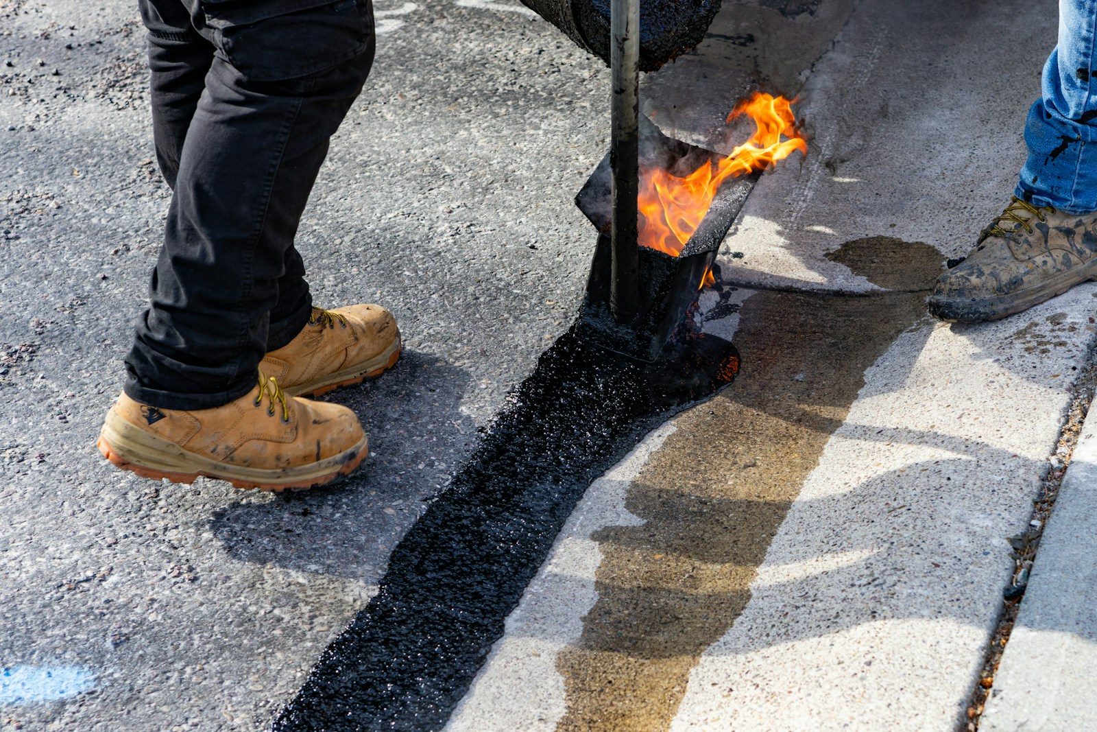 Workers applying a hot seal with a torch