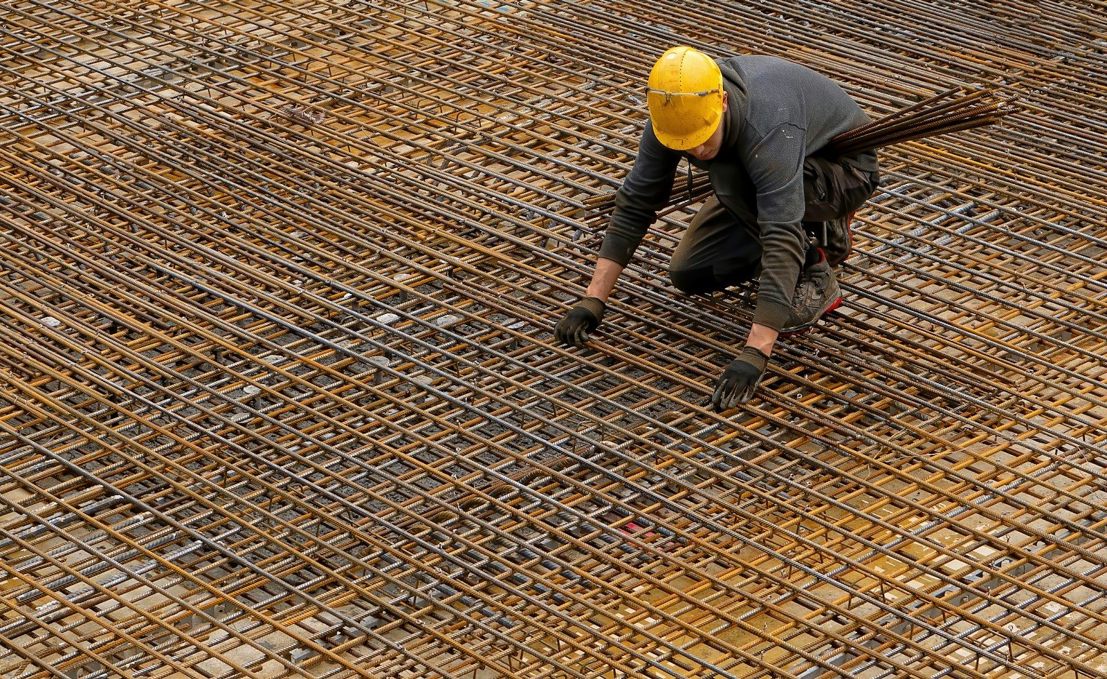 Worker in a hard hat fixing a foundation structure