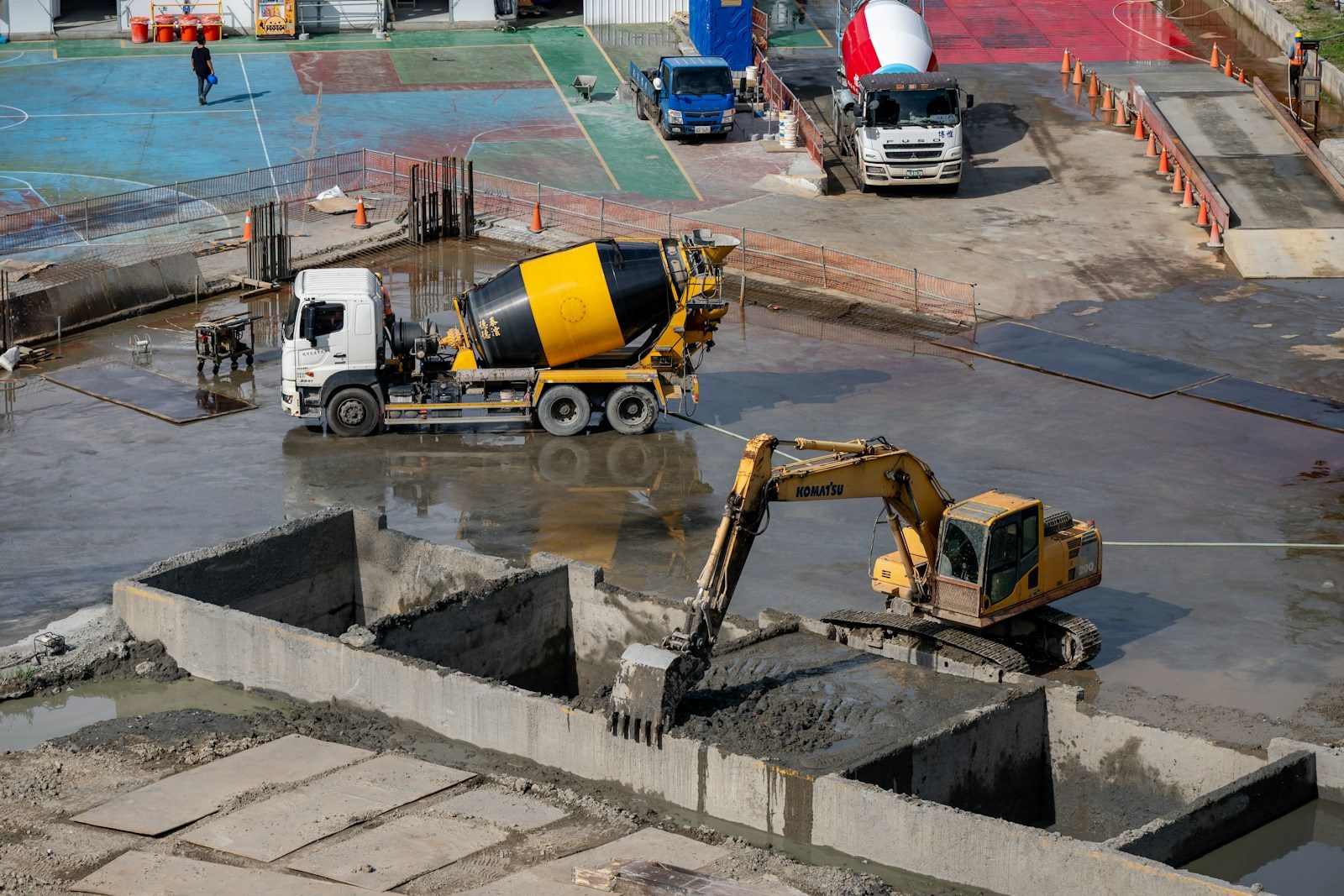Concrete mixer truck and excavator at a construction site