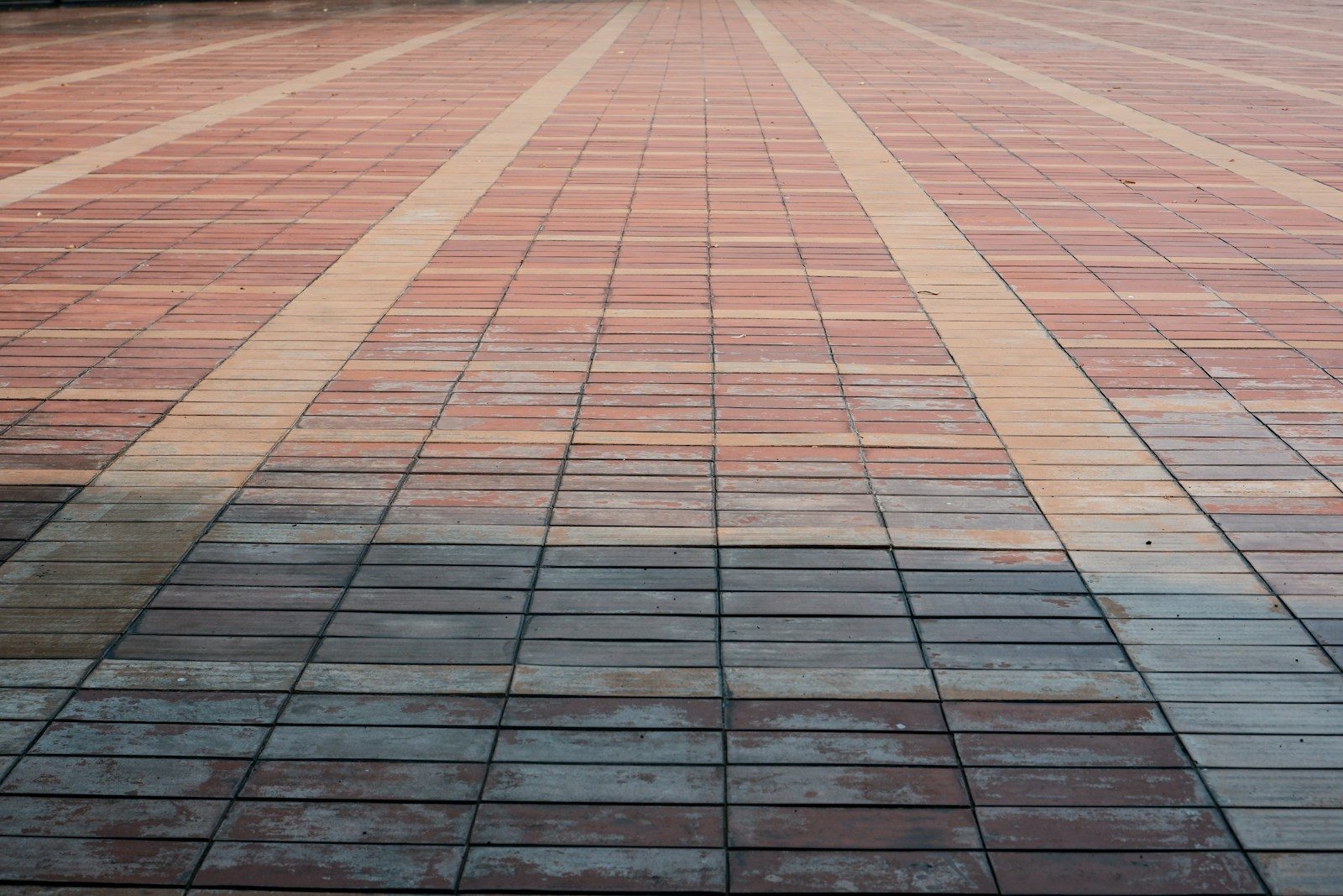 Red and gray patterned brick pavement with linear design